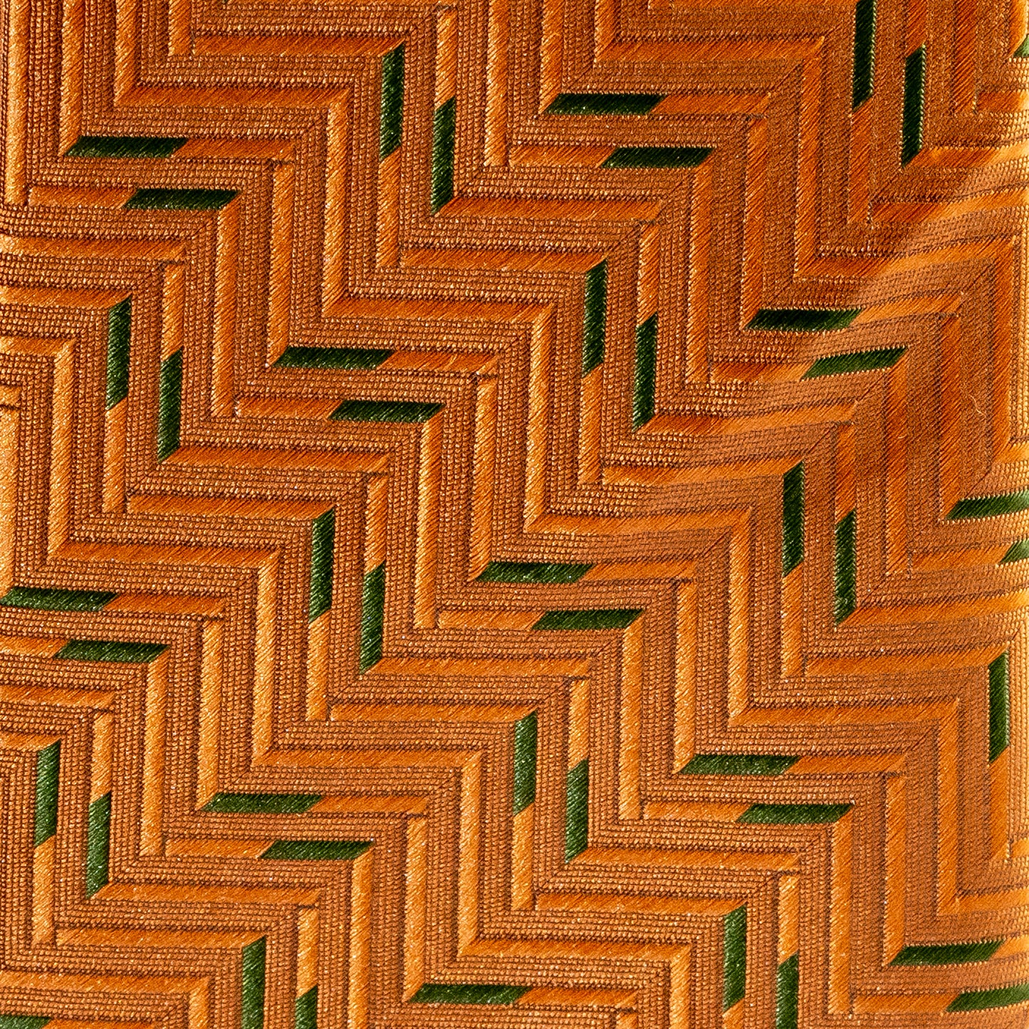 Close-up of a textured fabric with a geometric pattern in orange and green.